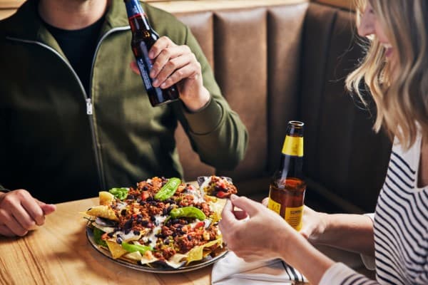 Man and woman sharing a plate of nachos